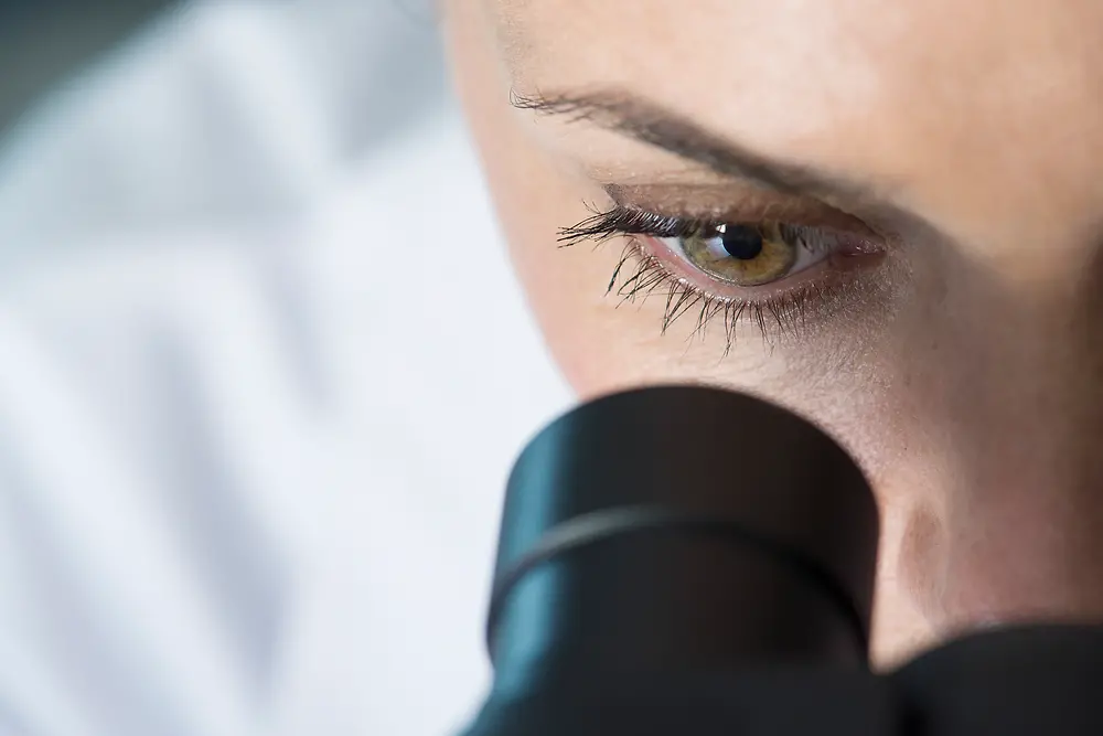 正在观察显微镜的女性的眼睛
