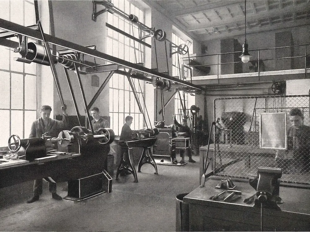 学徒在金属加工车间操作设备。