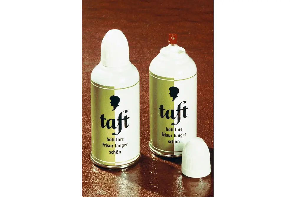 两只复古风格的“Taft”发胶包装罐，红棕色表面上配有白色盖子和金色标签。