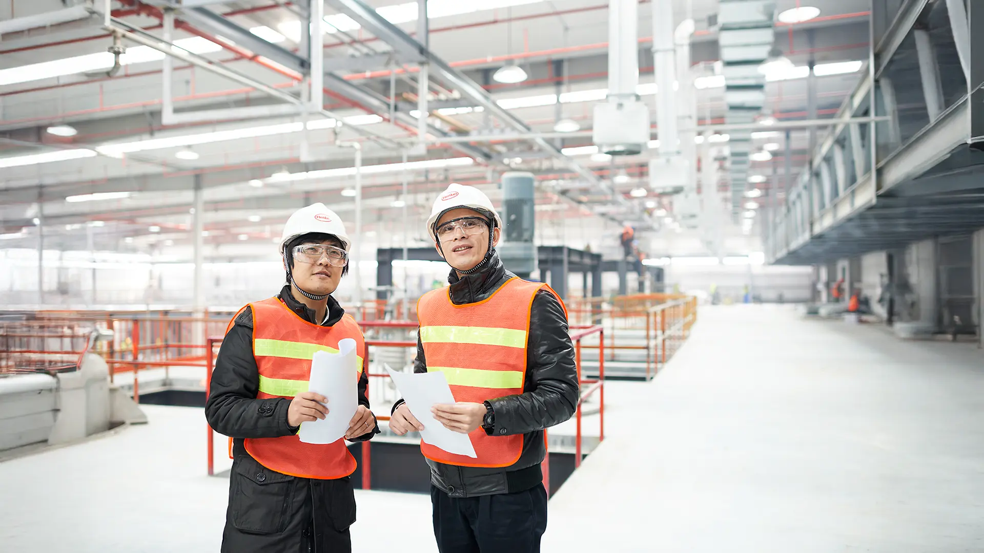 Two workers standing in front of the production line