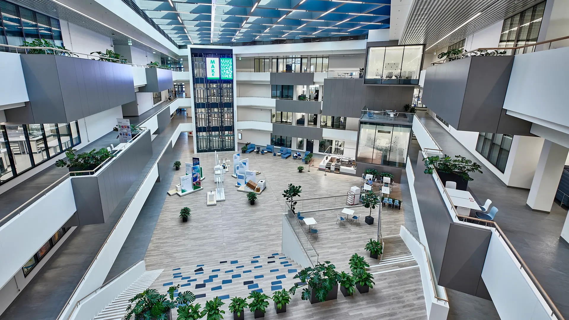 杜塞尔多夫创新体验中心内部视图，中间为大型中庭。该图还展示了玻璃幕墙设计的四层高科技实验室。